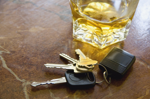 Photo of a glass of alcohol next to car keys